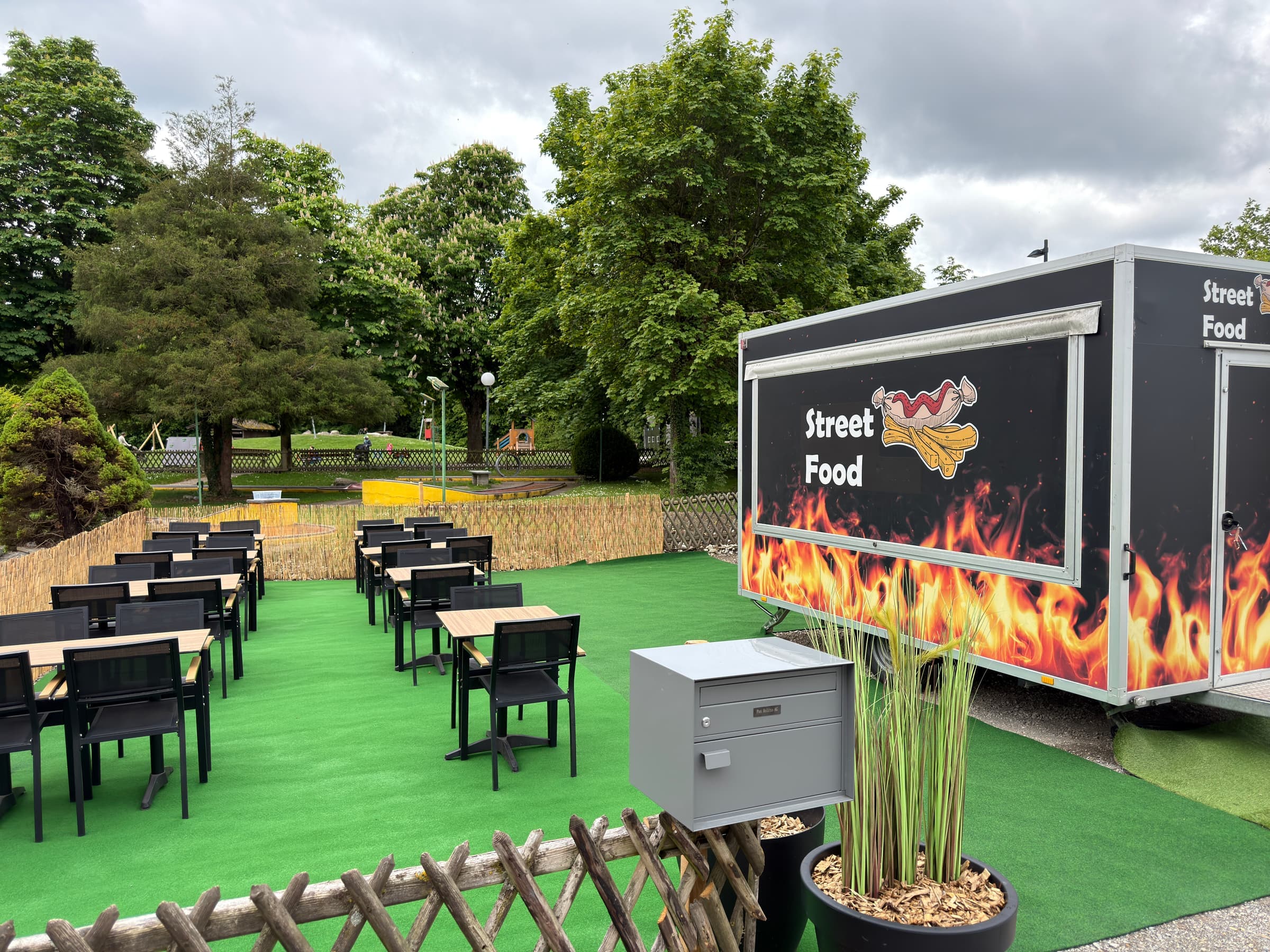 Street-Food-Truck und Sitzplätze auf Kunstrasen direkt neben der Minigolfanlage Pan Rolito.